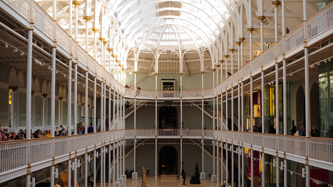 The inside of the National Museum of Scotland, looking like a Victorian train station with large skylights. 