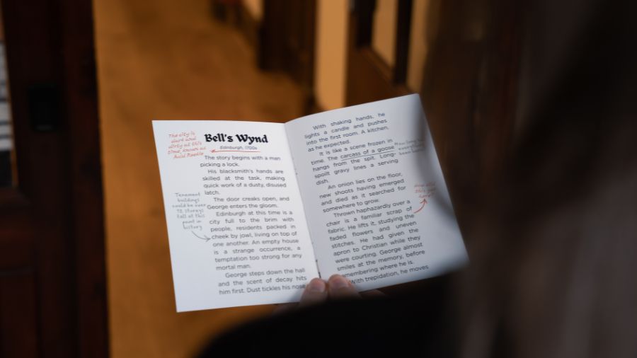  A photo taken over a woman’s shoulder as she reads a short story titled ‘Bell’s Wynd’ after an underground ghost tour in Edinburgh.