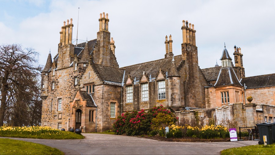 The front of Lauriston Castle, with a 16th-century tower and 19th-century extension all in sandstone.