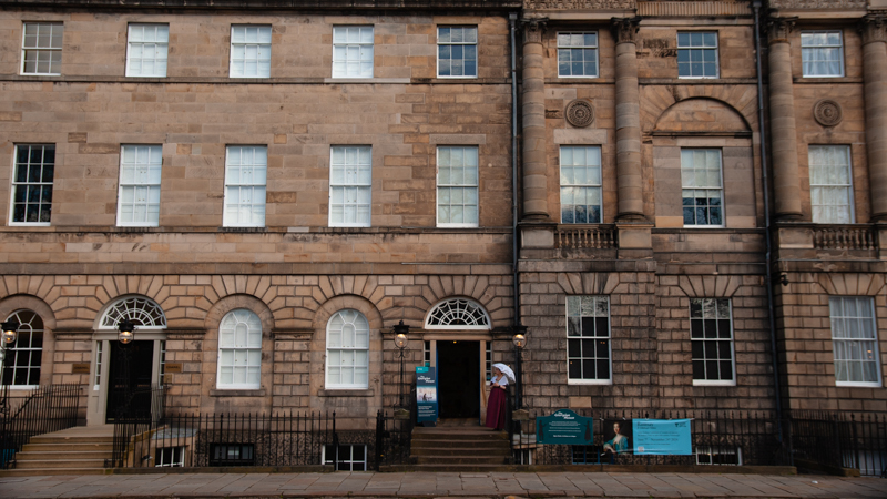 The front entrance to Edinburgh’s Georgian House, a woman in an 18th-century dress and parasol out front. 