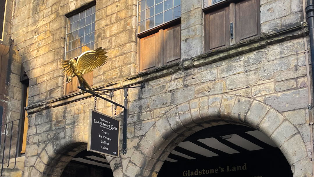 A golden eagle above the sign for Gladstone's Land historical building on Edinburgh's Royal Mile. 
