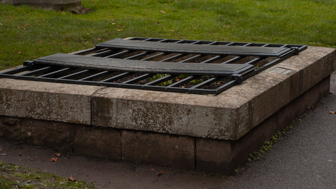 A large grave covered by iron bars in Greyfriars Kirkyard in Edinburgh.