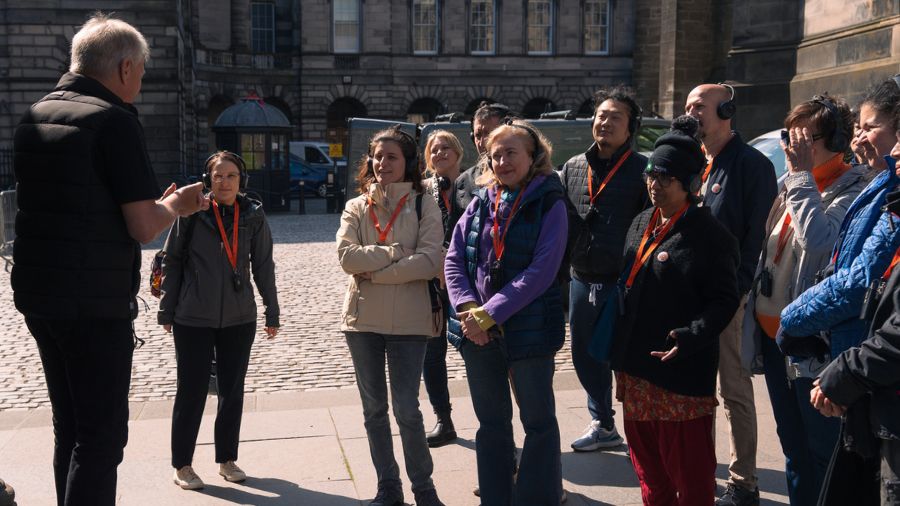 A dozen The Welcoming members and a Mercat Storyteller at the Edinburgh Mercat Cross.