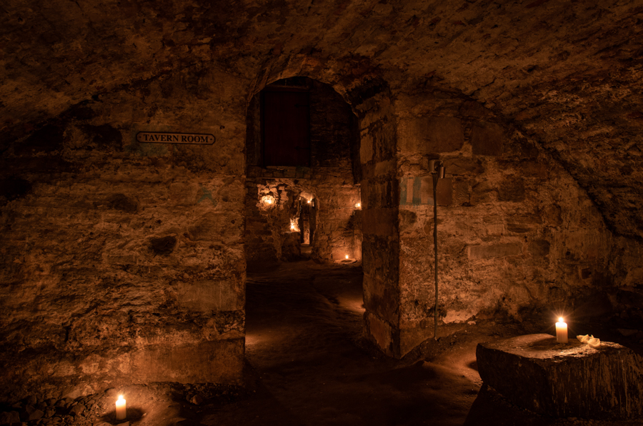 A candlelit stone room underground in Edinburgh's Blair Street Underground Vaults.