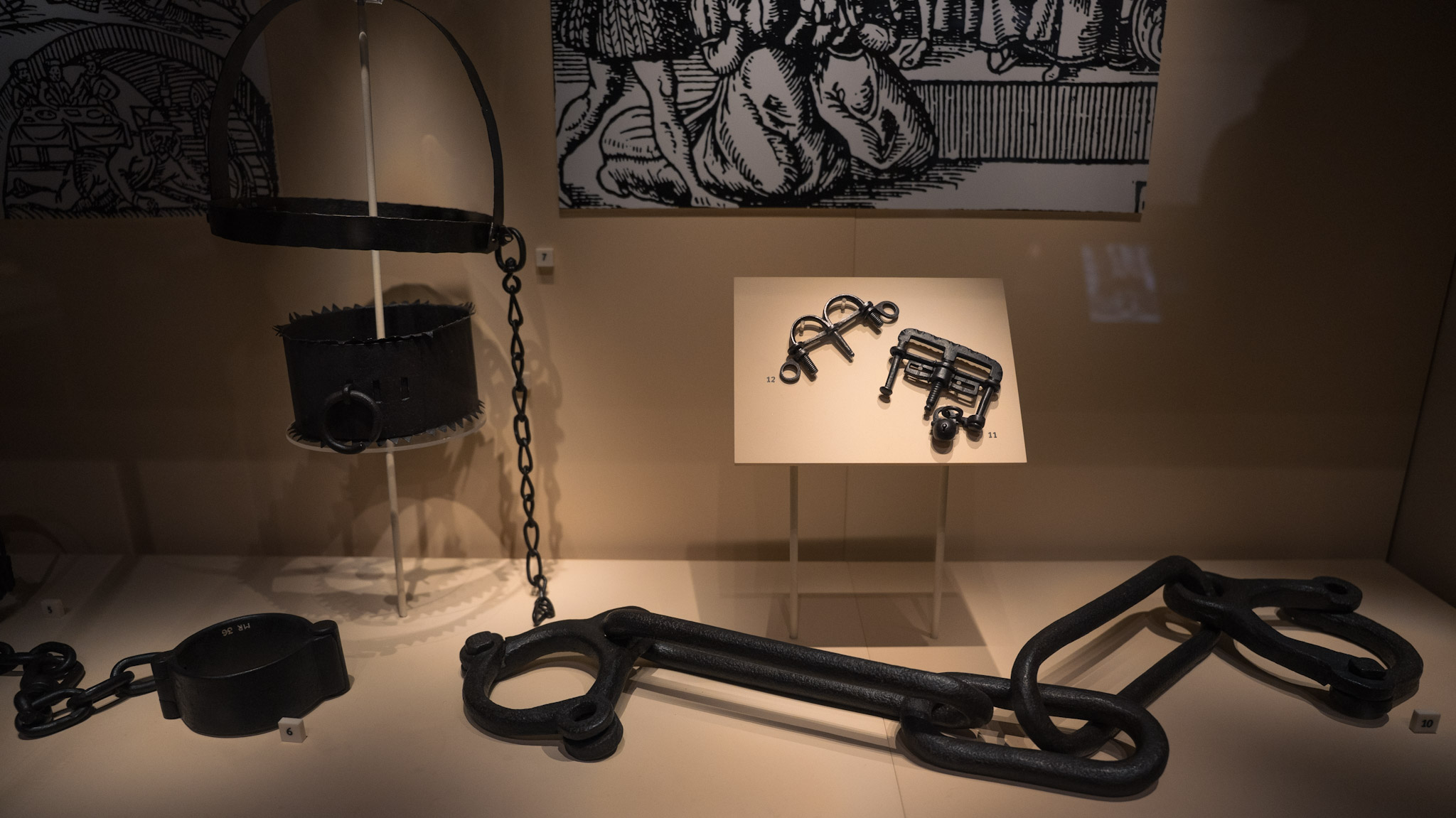 A display of iron interrogation instruments from the Scottish Witch Trials, including a collar, chains, and thumbscrews. 