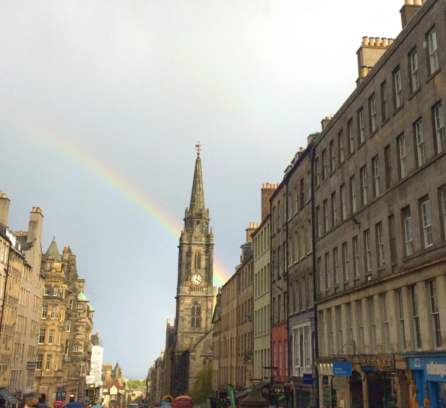 Edinburgh's Royal Mile with a view of a rainbow behind the Tron Kirk's spire
