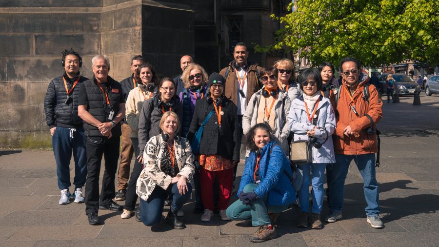 15 members of The Welcoming and a Mercat Storytelling stand outside St Giles’ Cathedral on the Edinburgh Royal Mile during a history tour of the Edinburgh vaults.
